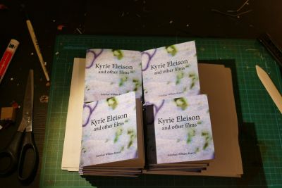 A stack of small, square zines.